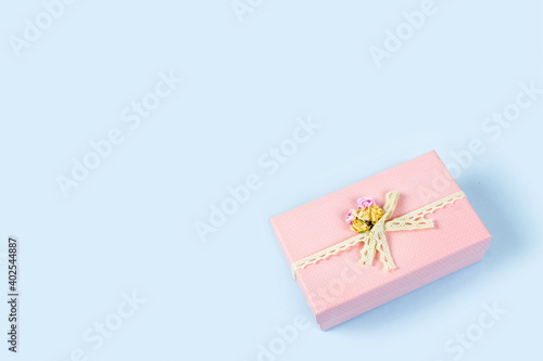 Beautiful pink gift box isolated on blue background. Copy space. © Lyubov