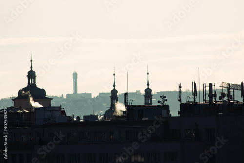 backlit Prague skyline buildings siwh smoke chimneys silhouette
