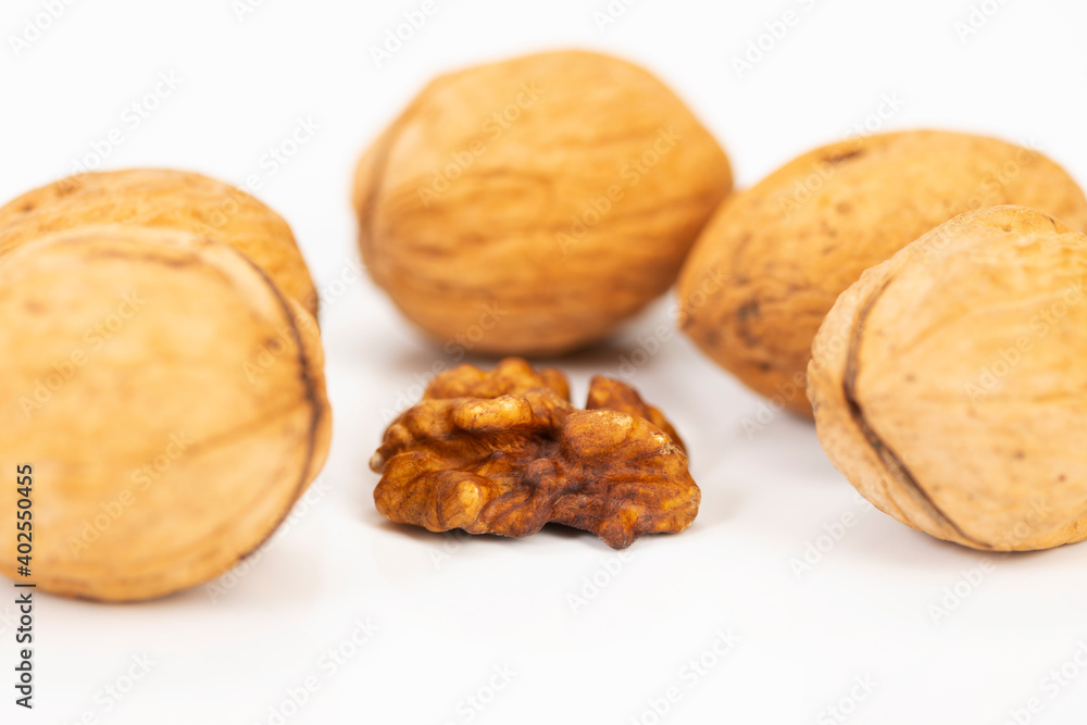 shelled walnuts and walnuts in shell on white background shelled walnuts and walnuts in shell on white background