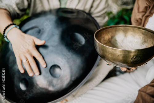 close up photo of handpan in a duet with Tibetan bowls in the hands of masters