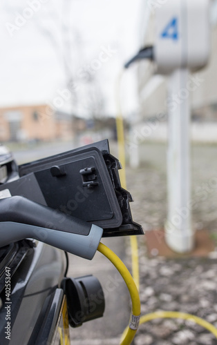 Petrol-electric hybrid car charging at urban charging station
