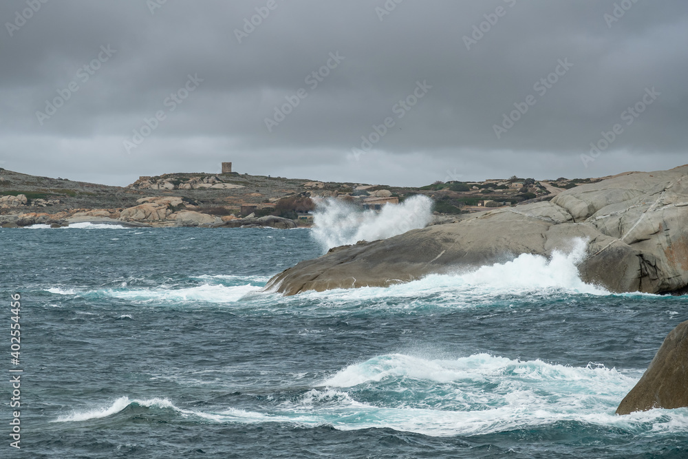 Mediterranean sea crashing into rocks and Genoese tower