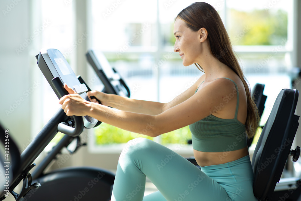 Healthy Lifestyle and Sport Concepts. Attractive young woman training on bike at the gym. Healthy Lifestyle and Sport Concepts. Attractive young woman training on bike at the gym.