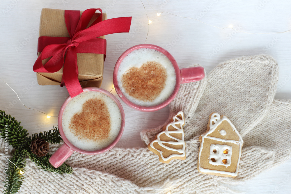two mugs with frothy cappuccino and hearts on the festive table top view. warming home-like atmosphere on the day of lovers two mugs with frothy cappuccino and hearts on the festive table top view. warming home-like atmosphere on the day of lovers
