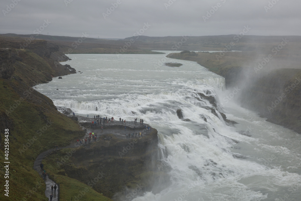 People visiting and experiencing the power of popular tourist destination - Gullfoss waterfall on Hvita river in Iceland People visiting and experiencing the power of popular tourist destination - Gullfoss waterfall on Hvita river in Iceland