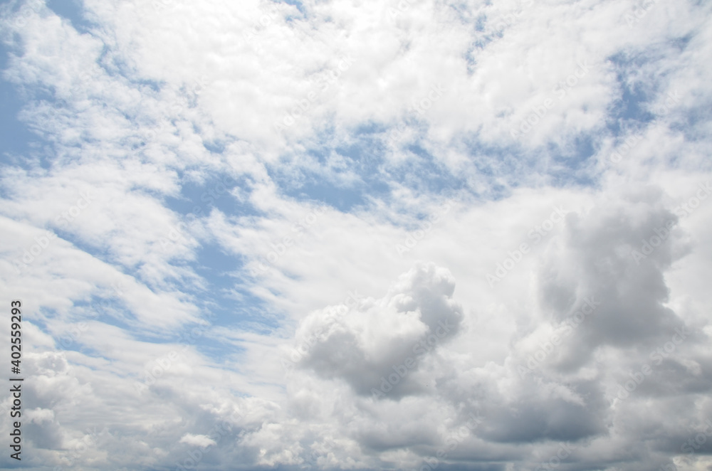 Naklejka premium Panorama of blue sky with white fluffy clouds in sunny weather. Background or texture