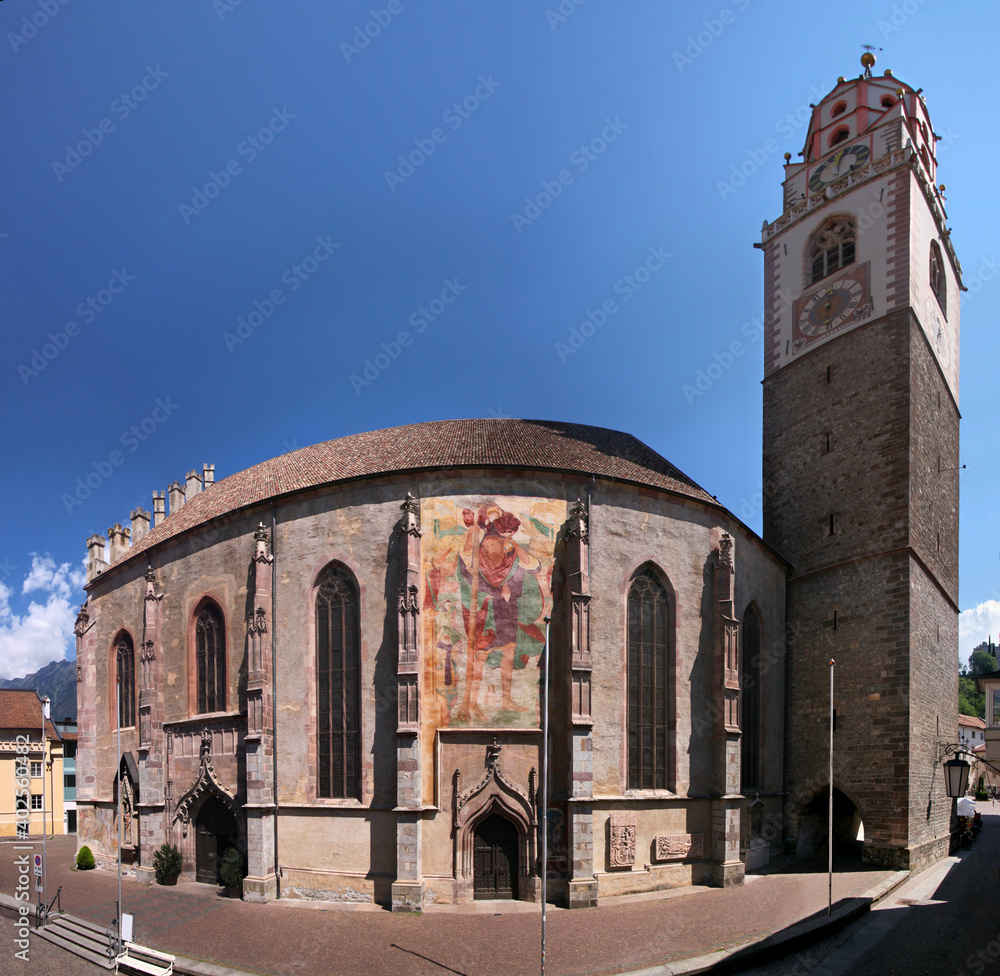 Fototapeta premium Panoramic view of the gothic St Nikolaus church with its bell tower in the old medieval town of Merano in South Tyrol, Italy