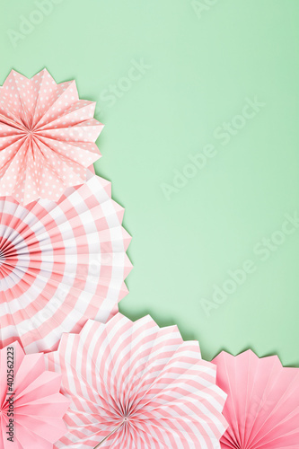 Festive party background with pink paper circle fans over pastel background. Festival  birthday  baby shower decoration