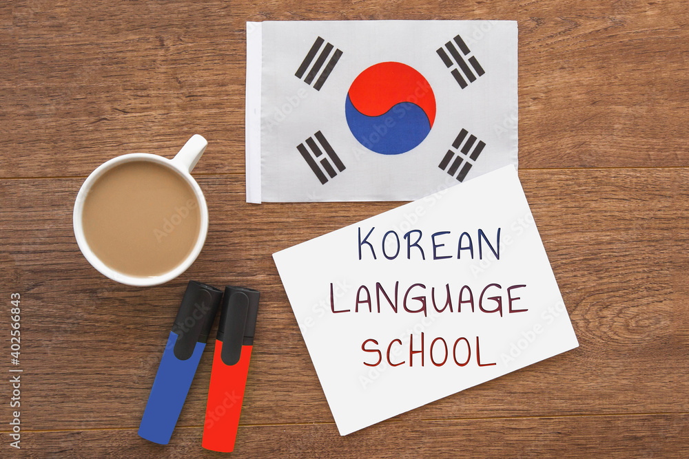 korean national flag, notebook with the inscription korean language school, two markers, cup of coffee on brown wooden desktop, study concept korean national flag, notebook with the inscription korean language school, two markers, cup of coffee on brown wooden desktop, study concept