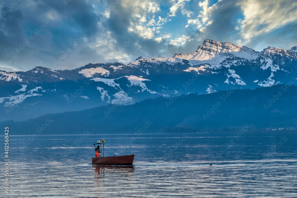Fishing boat on the waters of the Upper Zurich Lake (Obersee) on a winter morning in Hurden,, Schwyz, Switzerland