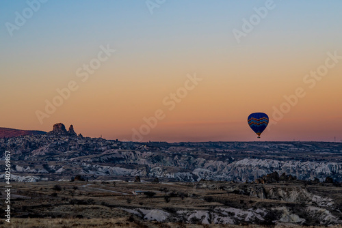 Hot air balloon rising in Cappadocia, Uchisar castle and city in