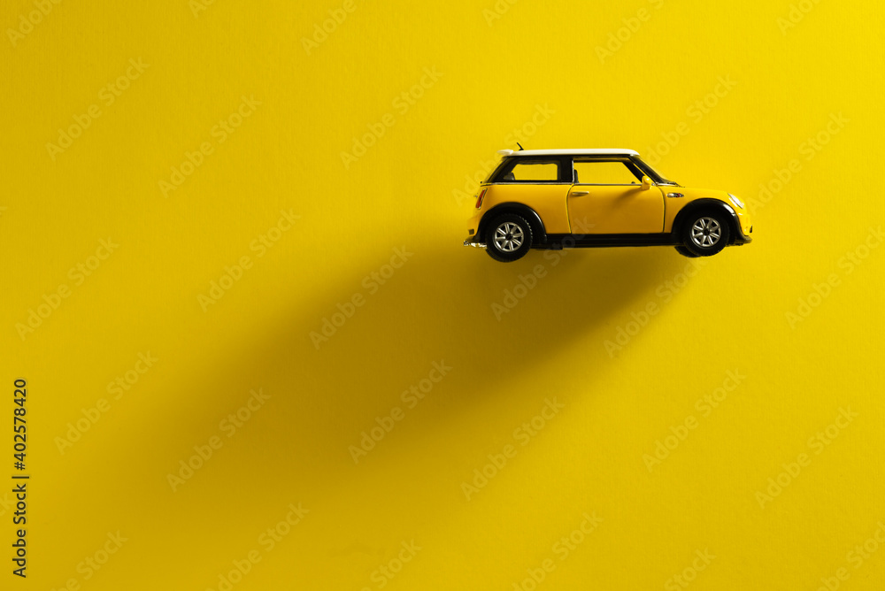 Side view of a Mini Cooper S Yellow toy car on a yellow background with ...