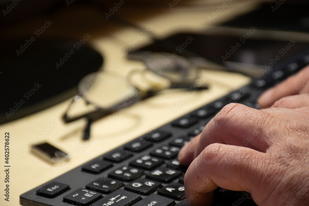 male hands on a computer keyboard male hands on a computer keyboard
