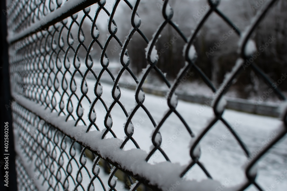 A chain-link fence that is frozen and snowed in A chain-link fence that is frozen and snowed in