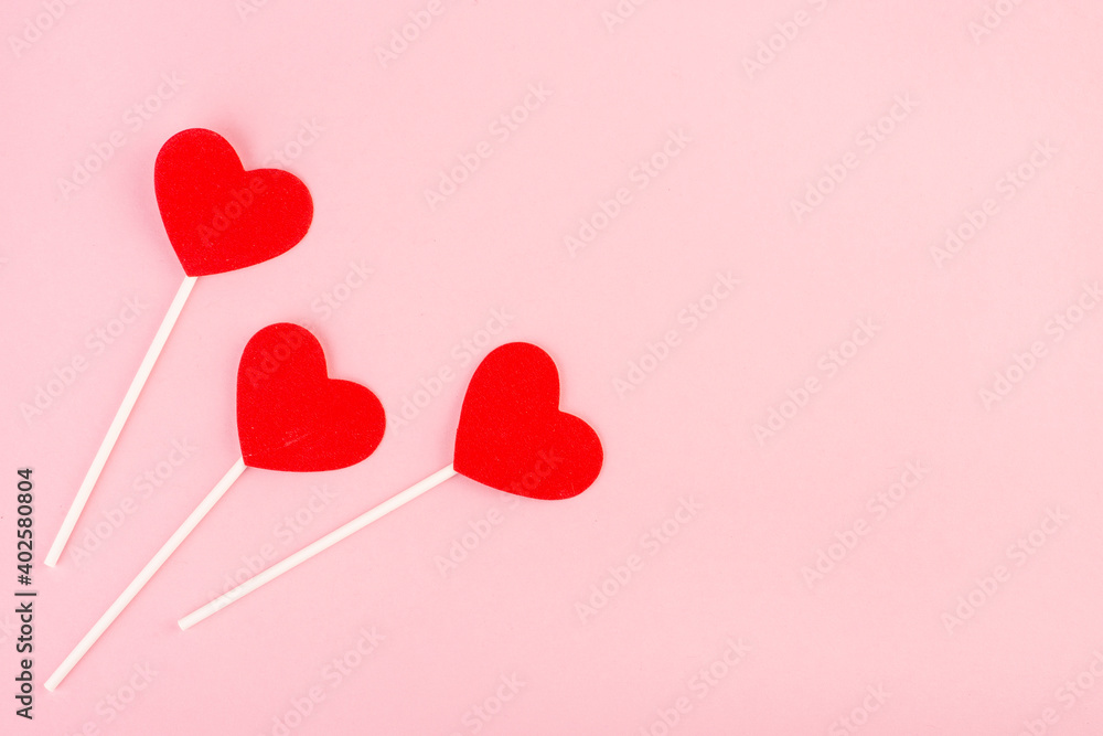 red hearts on a stick top view on pink background, Valentine's day background red hearts on a stick top view on pink background, Valentine's day background
