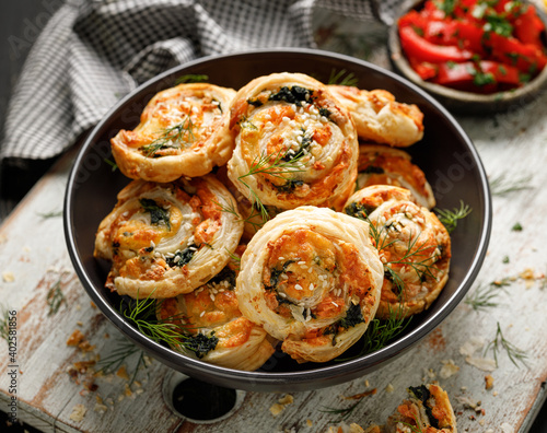 Foto Puff Pastry Pinwheels stuffed with salmon, cheese and spinach in a bowl close up