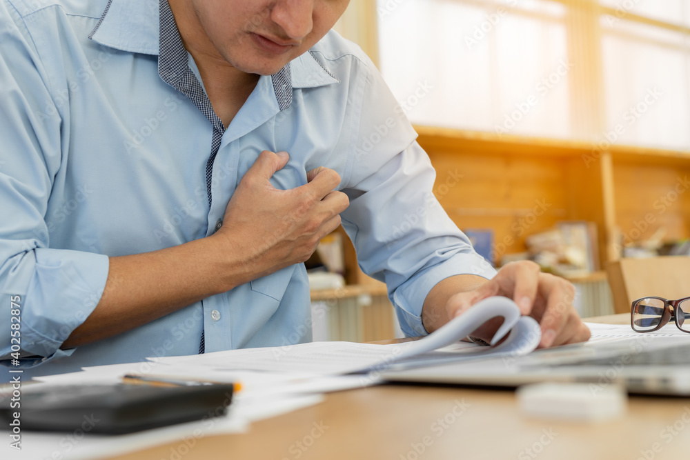 Businessman having chest pain and heart attack while working at office Businessman having chest pain and heart attack while working at office