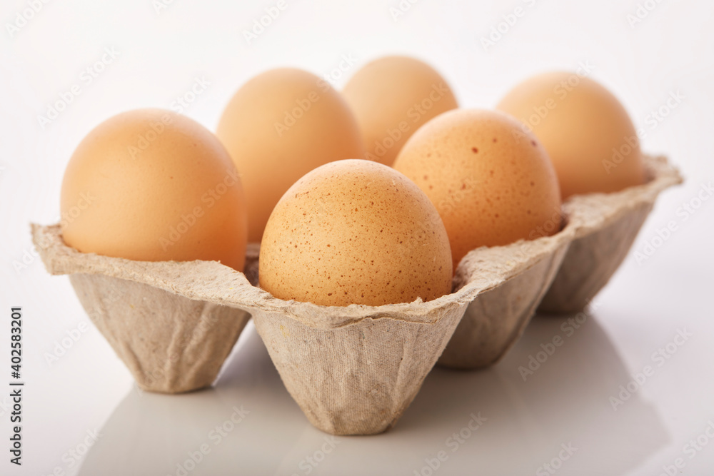 Brown eggs in egg box on white background. Brown eggs in egg box on white background.