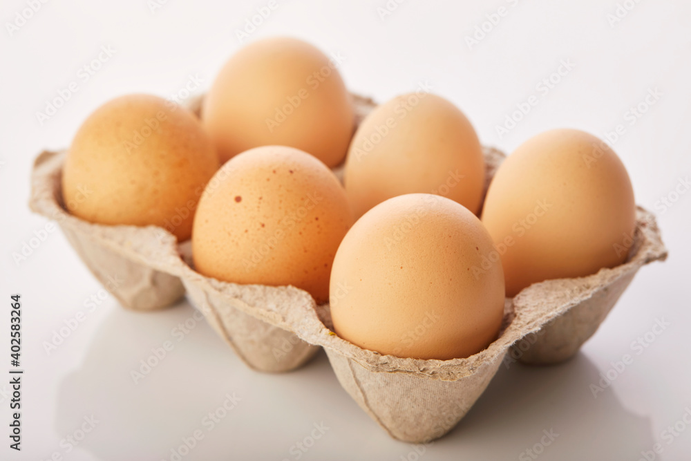 Brown eggs in egg box on white background. Brown eggs in egg box on white background.