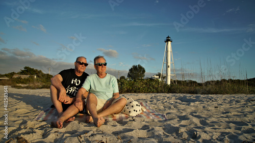 Obraz na plátně Senior gay male same-sex couple relaxing on the beach on the Gulf of Mexico Coas