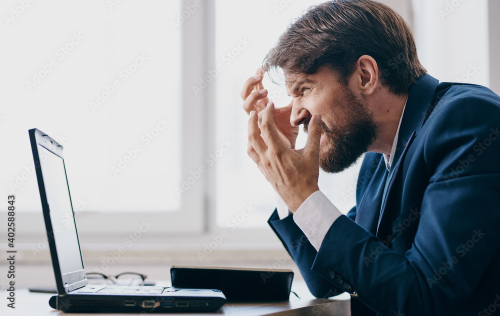 business man sitting at a table in a suit in front of a laptop emotions office manager business man sitting at a table in a suit in front of a laptop emotions office manager