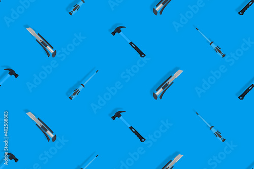 Tools seamless pattern. Tools: hammer, screwdriver and knife on a blue background.