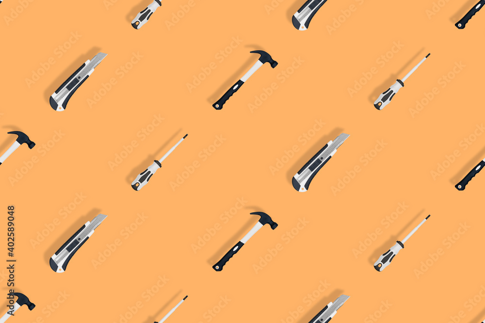 Tools seamless pattern. Tools: hammer, screwdriver and knife on an orange background. Tools seamless pattern. Tools: hammer, screwdriver and knife on an orange background.