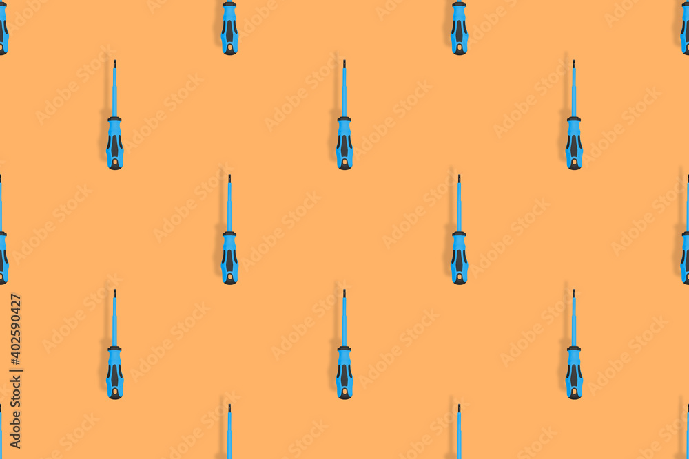 Screwdrivers seamless pattern. Metal screwdrivers with a rubberized handle on an orange background.
