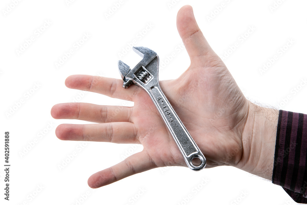 small silver adjustable wrench in the palm on a white small silver adjustable wrench in the palm on a white