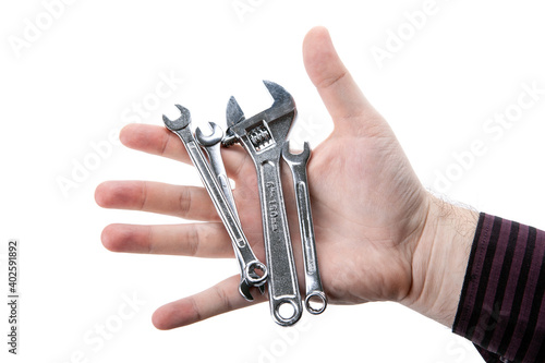 small slack wrenches and one adjustable wrench in hand isolated photo