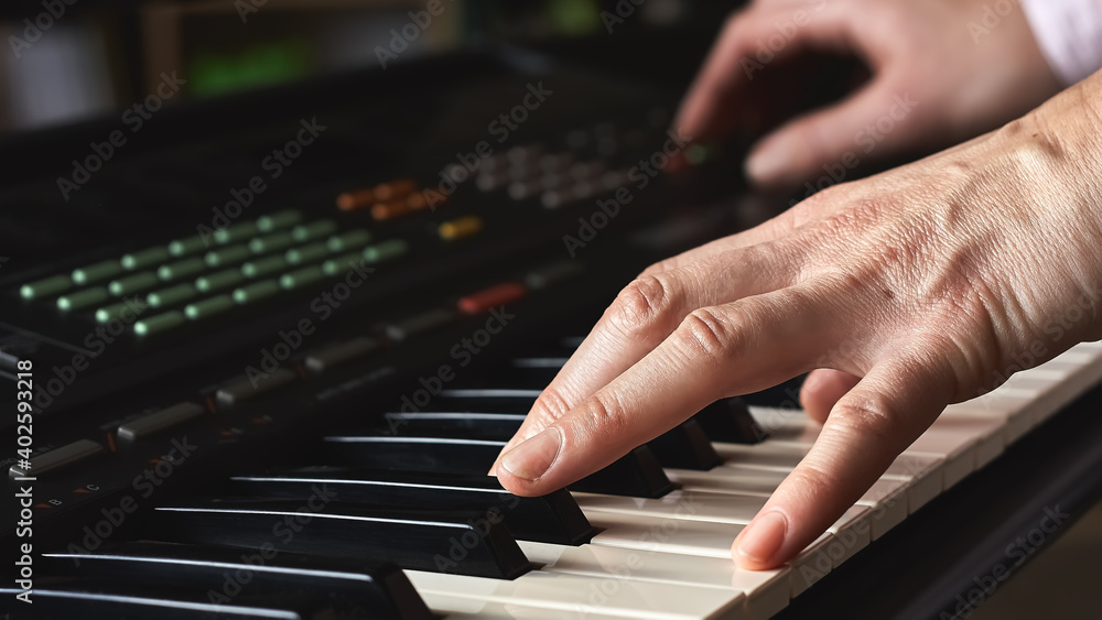 Fototapeta premium Female musician playing the digital piano or electronic keyboard at home. Music Education and Entertainment. Online music lessons.Soft selective focus