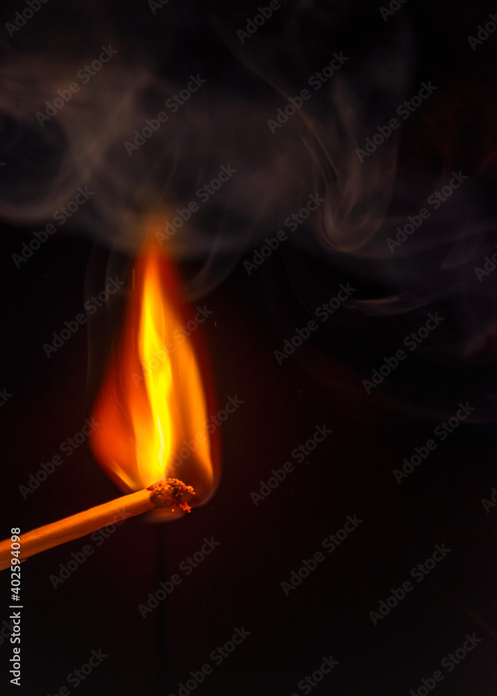 burning match with some smoke on black background burning match with some smoke on black background
