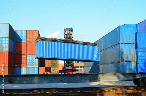 Shipping container loading by richtracker on the freight rail car at logistic warehouse port. Ocean Freight Cargo Shipping, Intermodal Container Freight concept - Image