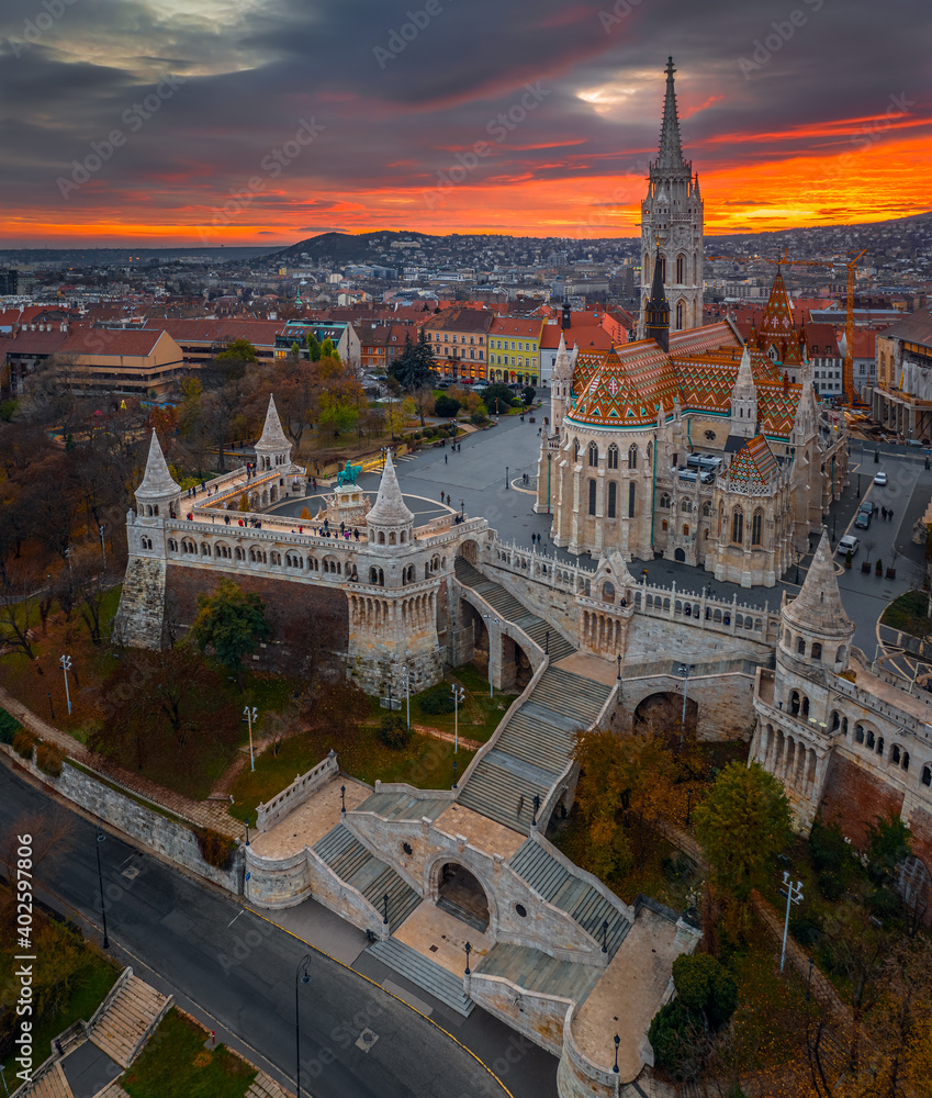Budapest, Hungary - Aerial view of the famous Fisherman's Bastion (Halaszbastya) and Matthias Church on an autumn afternoon with dramatic golden sunset behind. Festive lights and christmas decoration