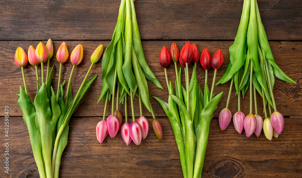 Tulips of different colors on wooden table Tulips of different colors on wooden table