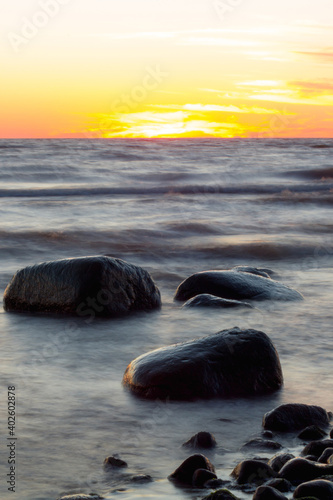 Rocks in the sea. Summer landscape in Europe. Colorful sunset or sunrise, portrait capture. Travel and vacation concept.