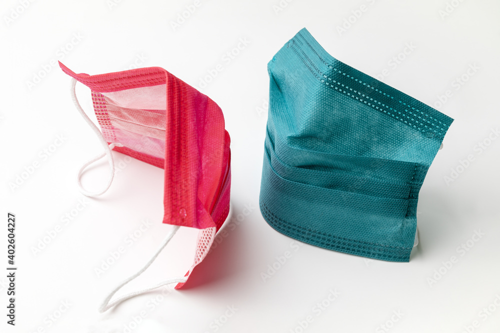 Two colored medical masks are turned towards each other. Concept love, Valentine's Day during the 2021 pandemic Two colored medical masks are turned towards each other. Concept love, Valentine's Day during the 2021 pandemic
