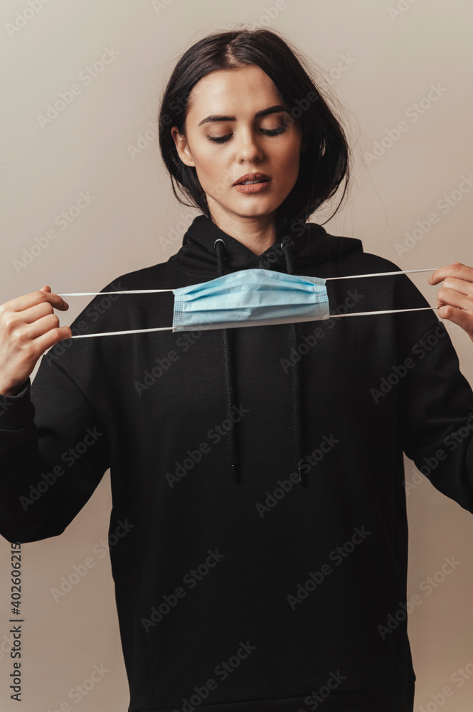 Medical face mask for protection from viruses, used by brunette female Medical face mask for protection from viruses, used by brunette female