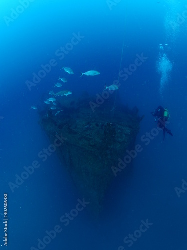 scuba divers exploring shipwreck scenery underwater ship wreck deep blue water ocean scenery of metal underwater