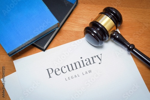 Pecuniary. Document with label. Desk with books and judges gavel in a lawyer's office.