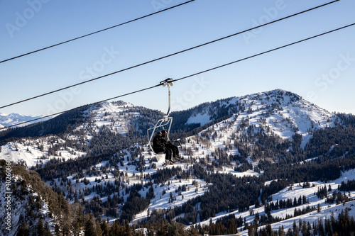 People on chairlift with scenic snowy mountain background