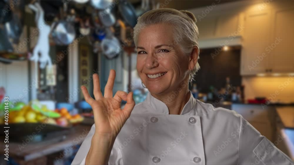 Socking Cook Portrait of pretty, mature woman cook giving and okay sign with her ...