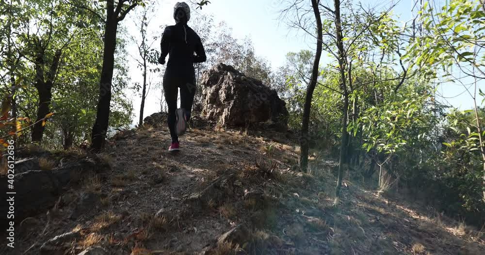 Fitness asian woman running on trail at sunrise tropical forest Fitness asian woman running on trail at sunrise tropical forest