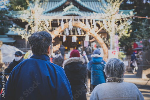 参拝の列に並ぶ2人の高齢者の背中; 神社にて
