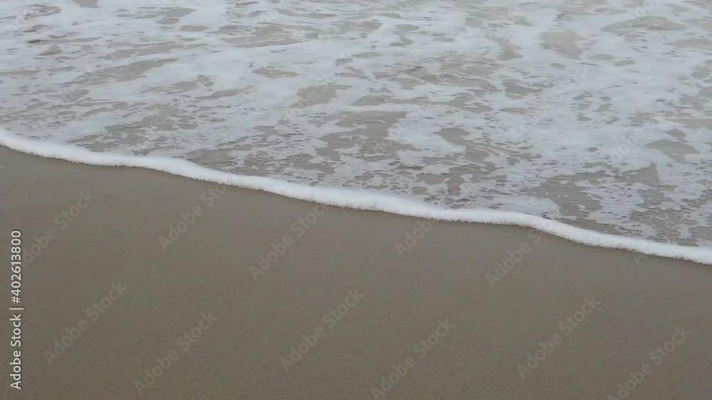 Sea water waves on sandy beach. Splashes of water and foam in slow motion. Sea water waves on sandy beach. Splashes of water and foam in slow motion.