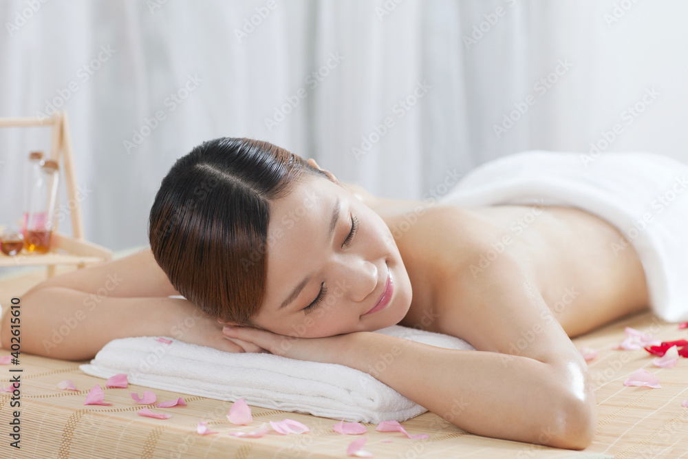 A young women lying in bed enjoying massage A young women lying in bed enjoying massage