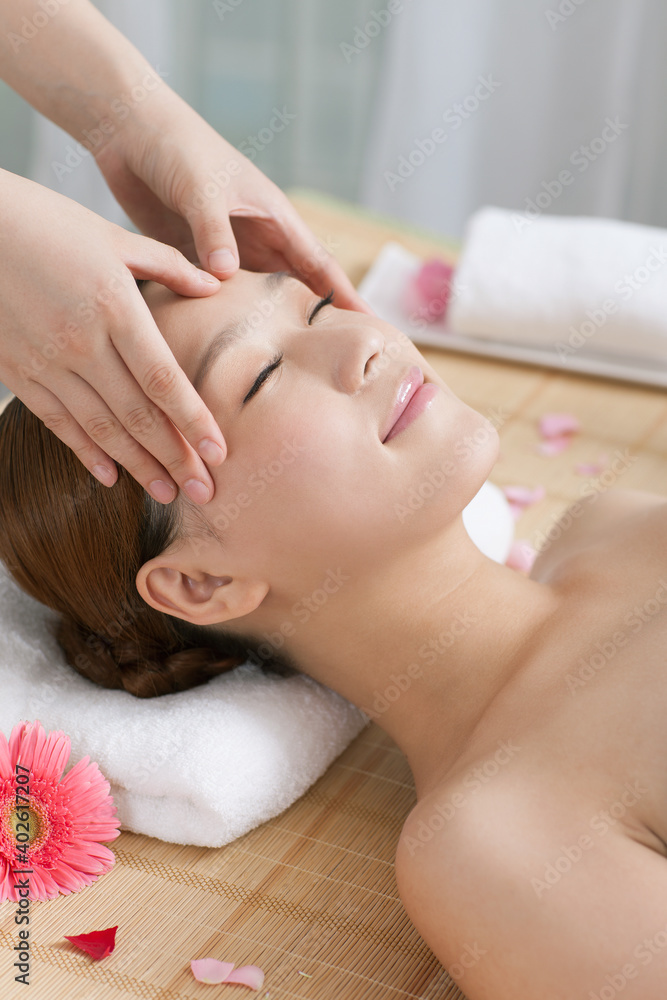 A young women lying in bed enjoying massage A young women lying in bed enjoying massage