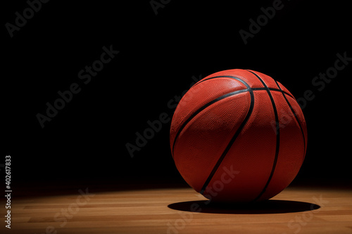 BASKETBALL BALL ON WOODEN COURT ON DARK BACKGROUND. BETS IN SPORTS. COPY SPACE.