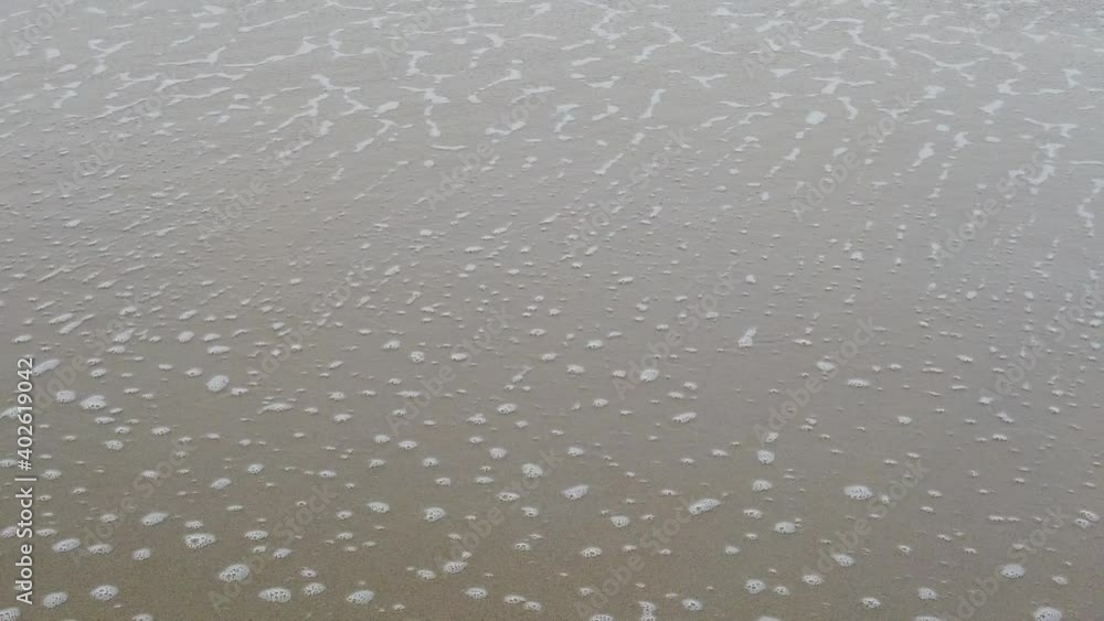 Sea water waves on sandy beach. Splashes of water and foam in slow motion. Sea water waves on sandy beach. Splashes of water and foam in slow motion.