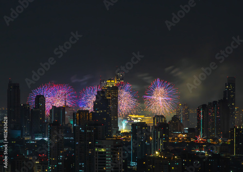 Colorful Firework with cityscape night light view of Bangkok skyline at twilight time. New Year celebration fireworks light up to sky at New Year festival with Copy space. No focus, specifically. © num